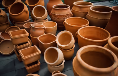 Collection of traditional clay pots displayed outdoors in a craft market.jpg